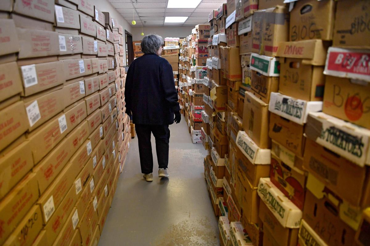 Connie Schroeder walks among the boxes of books at the AAUW building on Wednesday. The annual AAUW State College Used Book Sale, which had been planned mid-May, has been postponed.
