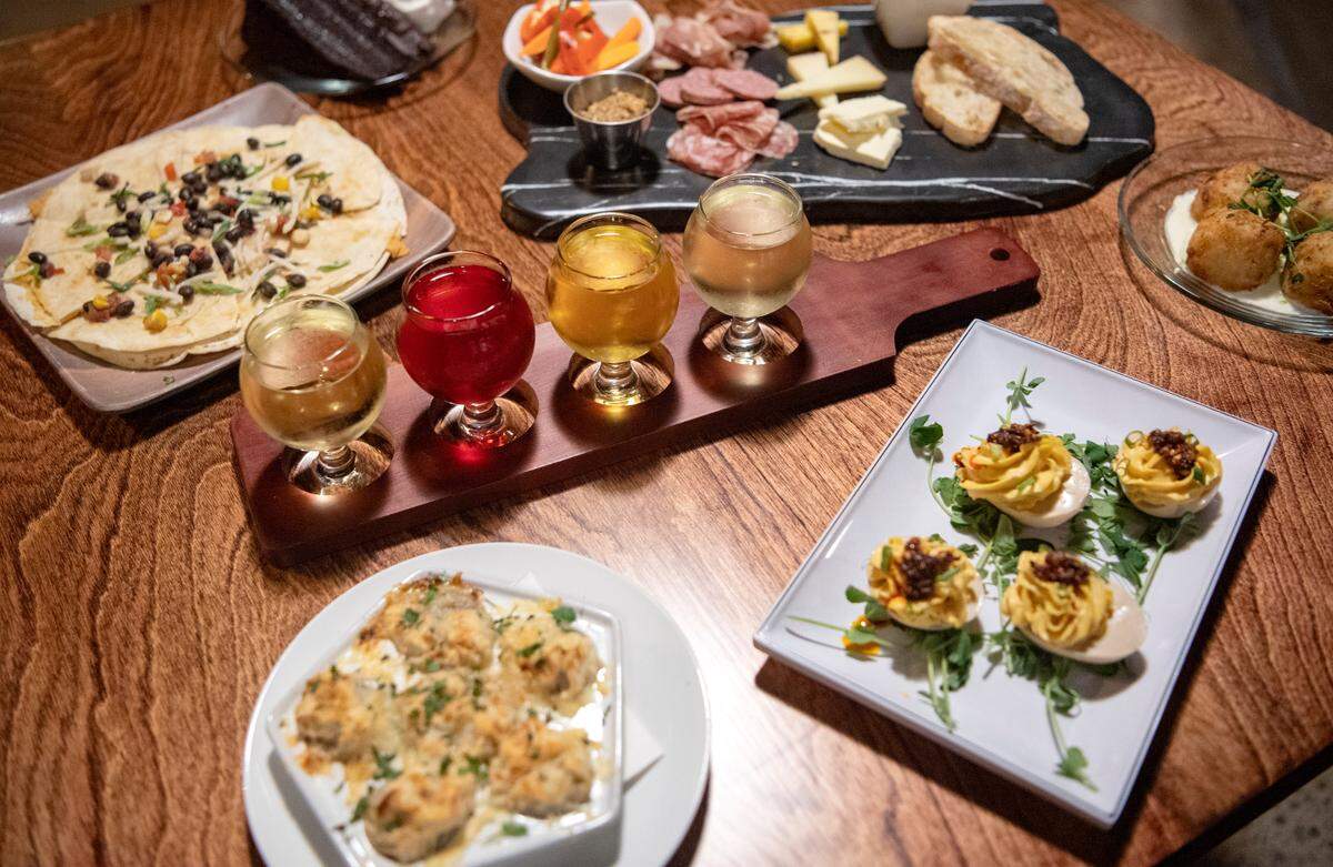 A variety of small plates from Alloy Kitchen and a flight of Mad McIntosh Cider on Wednesday, April 13, 2022.