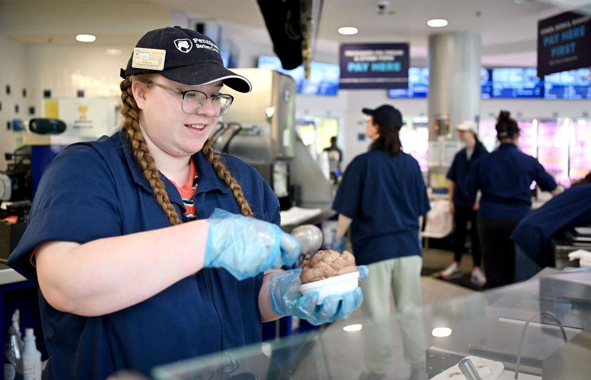 Ella Bradner scoops a dish of Death By Chocolate ice cream at the Penn State Berkey Creamery on Thursday, May 16, 2024.
