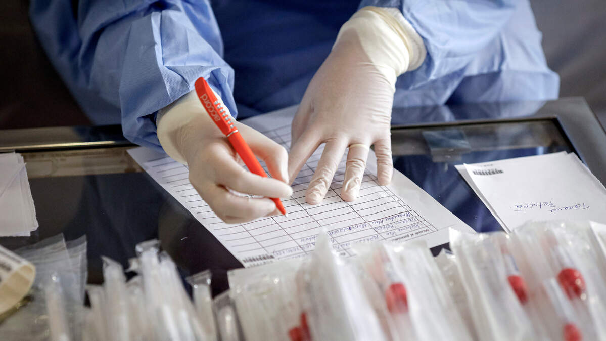 A health official prepares to take samples for a coronavirus test from a journalist in Bucharest, Romania, Friday, March 13, 2020 after it was confirmed that a senator who attended several meetings in the building tested positive for the infection. The caretaker prime minister of Romania, Ludovic Orban, said in a press conference at the parliament, the government, including all ministers, as well as the leadership of the ruling National Liberal Party and all its senators, are going into quarantine after one of the governing party’s senators, who took part in high-level meetings, who confirmed to be infected with the coronavirus. (AP Photo/George Calin)