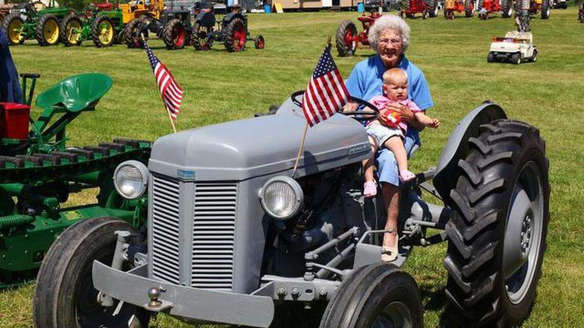 Millie Hoffman, 83, holds great-granddaughter Clara Franklin, 1, while sitting on a Ferguson tractor Millie drove during the tractor parade at the spring Nittany Antique Machinery Show at Penn’s Cave in Centre Hall on Sunday.
