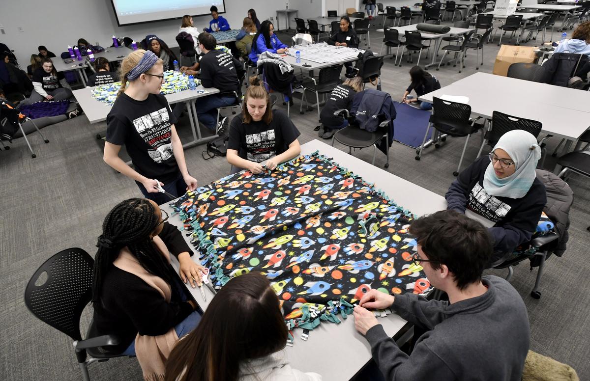 A group of Penn State student volunteers make fleece blankets donate during the Dr. Martin Luther King Jr. service day on Monday, Jan. 21, 2019.