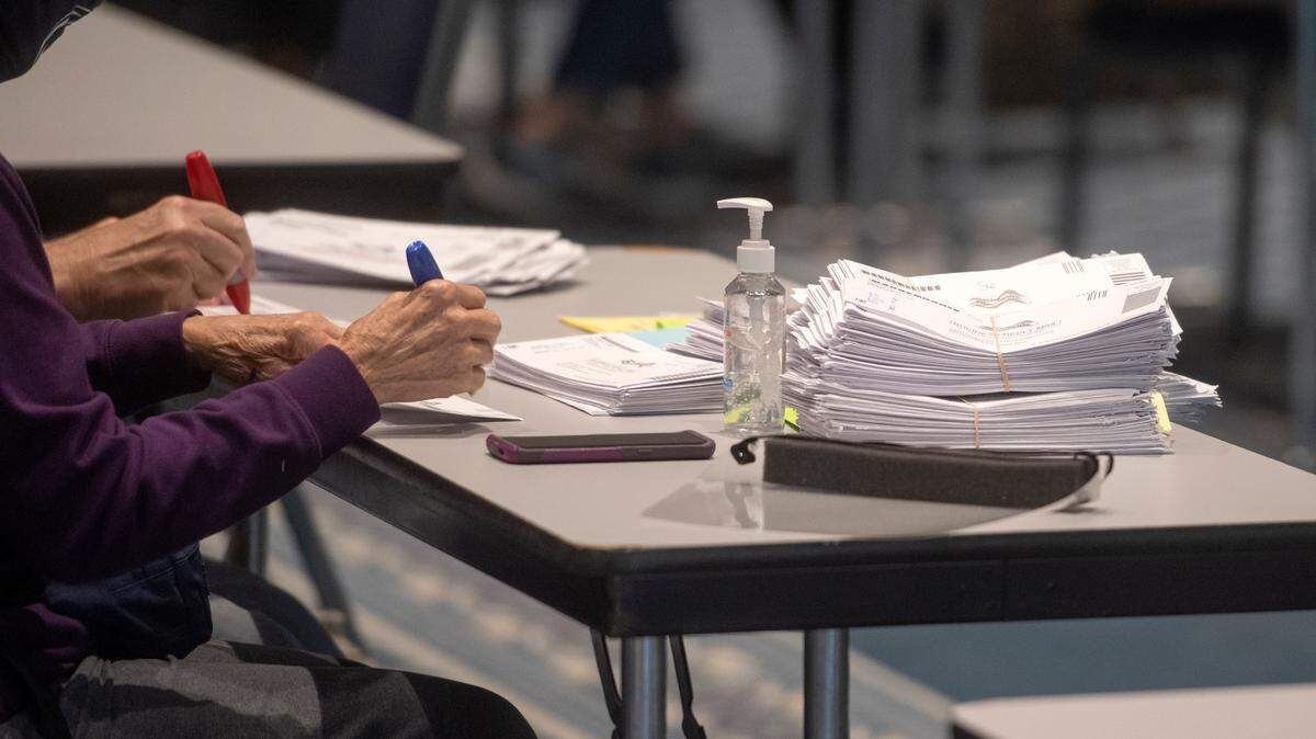 Volunteers make sure the ballots have been removed from the envelopes at the election office site at the Penn Stater where the mail in ballots were being processed on Tuesday, Nov. 3, 2020.