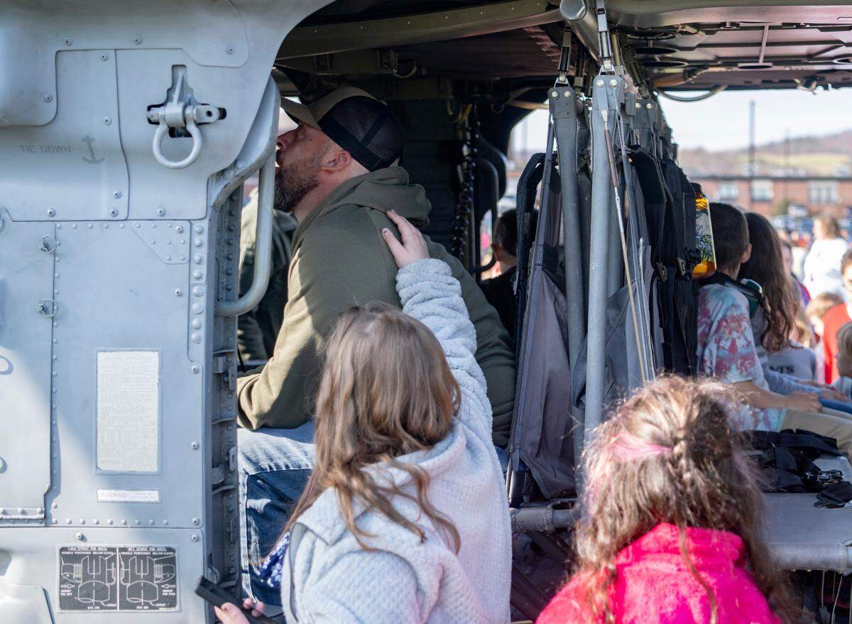 Lance Cpl. USMC retired Aaron King is comforted by his daughters Layla Blair-King and Leah Blair-King as he sits in one of the MH-60S helicopters that were flown in to the Bald Eagle Area Veterans Day celebration on Thursday, Nov. 9, 2023.