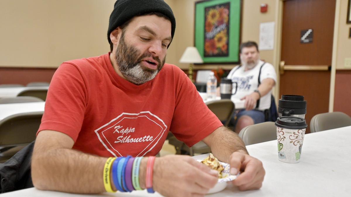 Tobias Egen chats with others as he eats a bowl of food on Tuesday, Nov. 20, 2018.  Out of the Cold: Centre County is now offering daytime shelter hours and lunch, which many local restaurant donate to, like Tuesday’s lunch from Indian Pavilion.