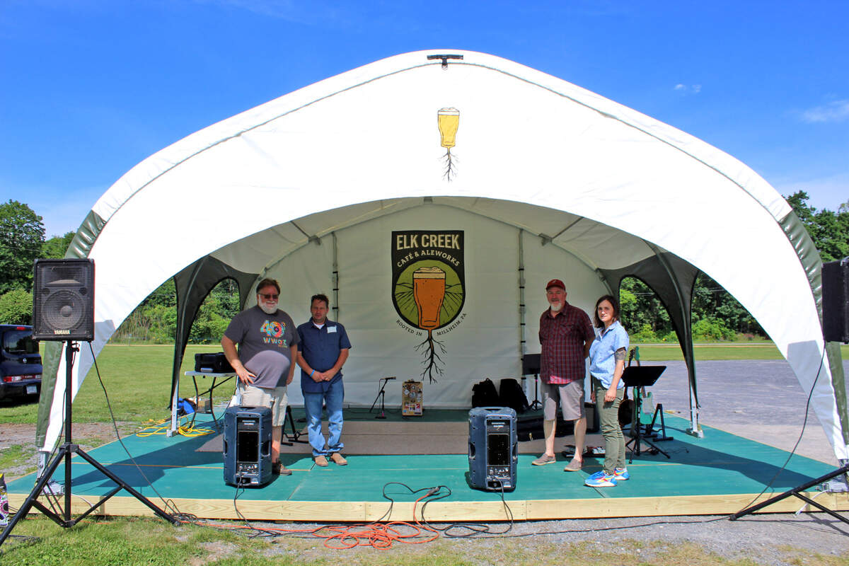 The Elk Creek Cafe purchased a high-tech stage, seen here in 2021, that can withstand 70 mph winds for its outside live outdoor music events. From left, are Steve Crawford, of the Elk Creek Cafe’s house band, The Poe Valley Troubadors, Sean Hershey, of The Dilly Beans, Tim Bowser, Elk Creek Cafe proprietor, and Hannah Bingman, of The Dilly Beans.