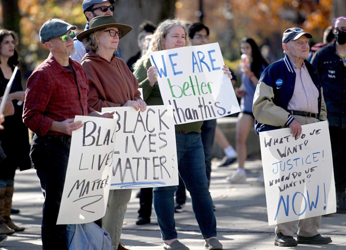 Rally attendees hold up signs at the “We Believe in Anti-Racism and Racial Justice at Penn State” event Thursday hosted by a committee of concerned Penn State faculty outside of Old Main.