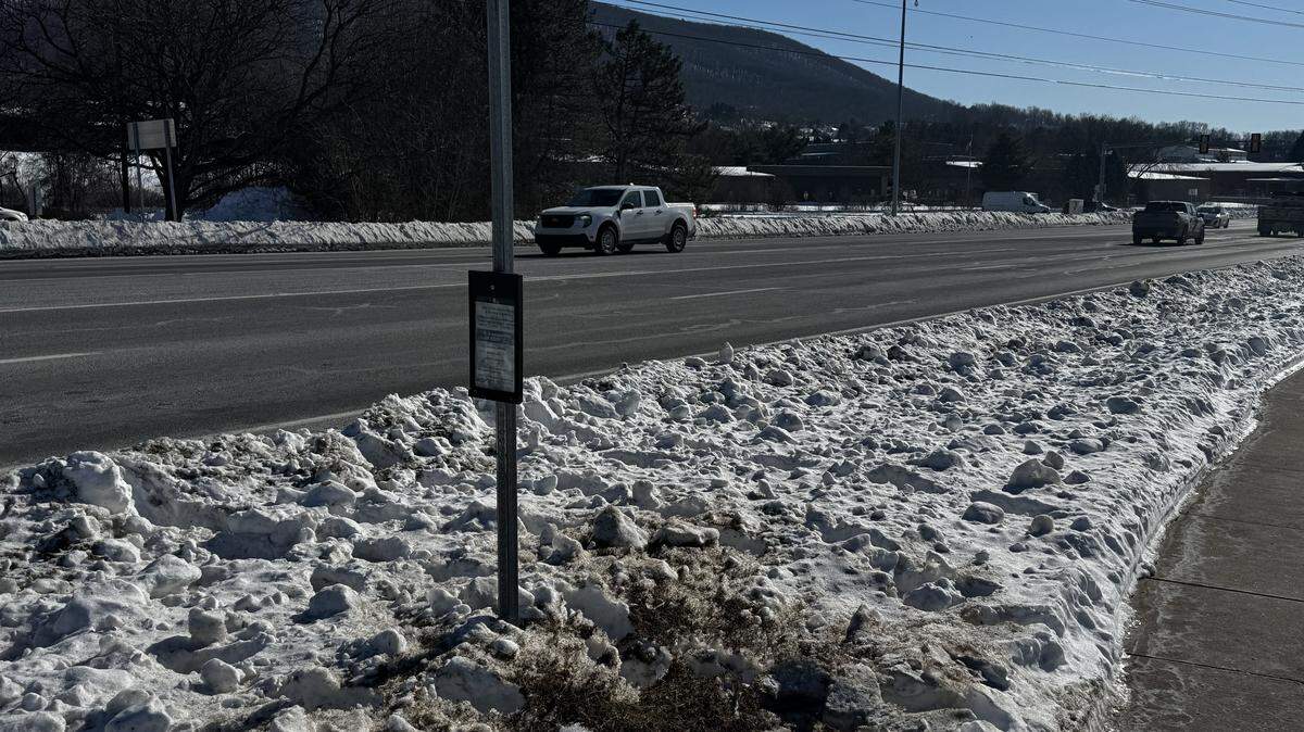 Several yards of snow separate the sidewalk from the road at a bus stop on Benner Pike Feb. 2, 2026.