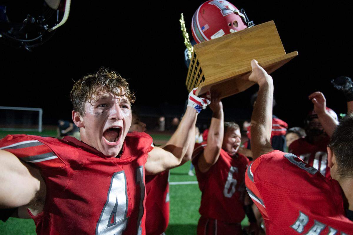 Bellefonte’s Nolan Weaver raises the Luther Trophy and after defeating Philipsburg-Osceola High School in a high school football game on Friday, Sept. 3, 2021.