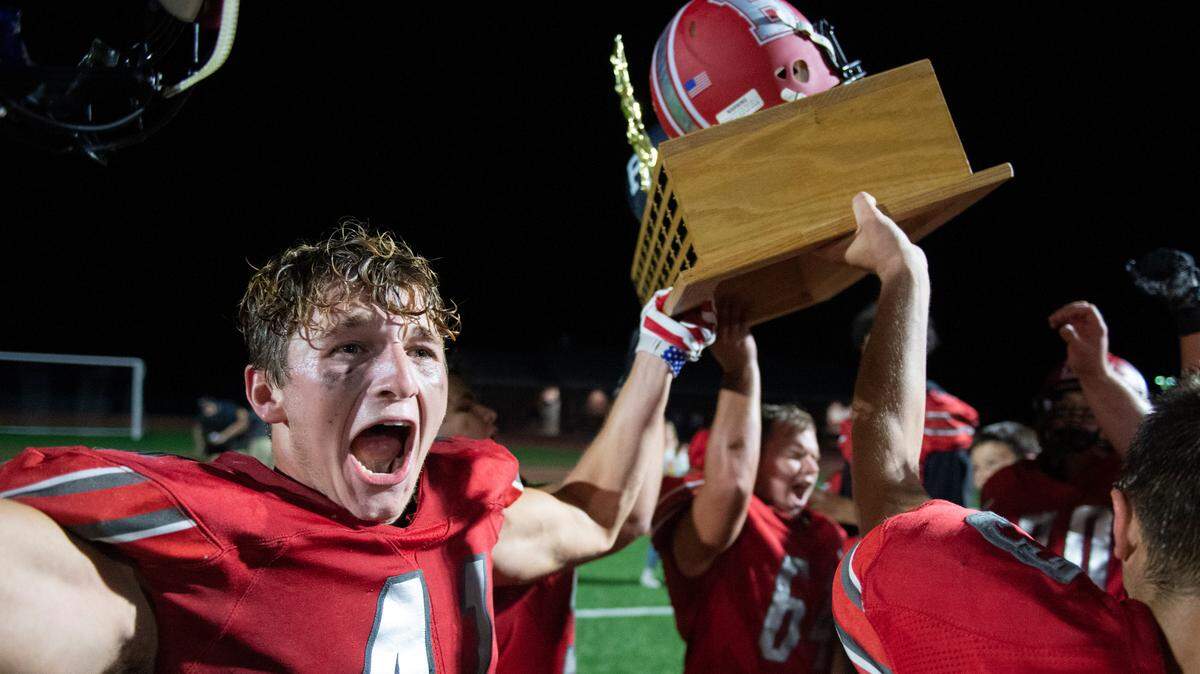 Bellefonte’s Nolan Weaver raises the Luther Trophy and after defeating Philipsburg-Osceola High School in a high school football game on Friday, Sept. 3, 2021 in Bellefonte, Pa.