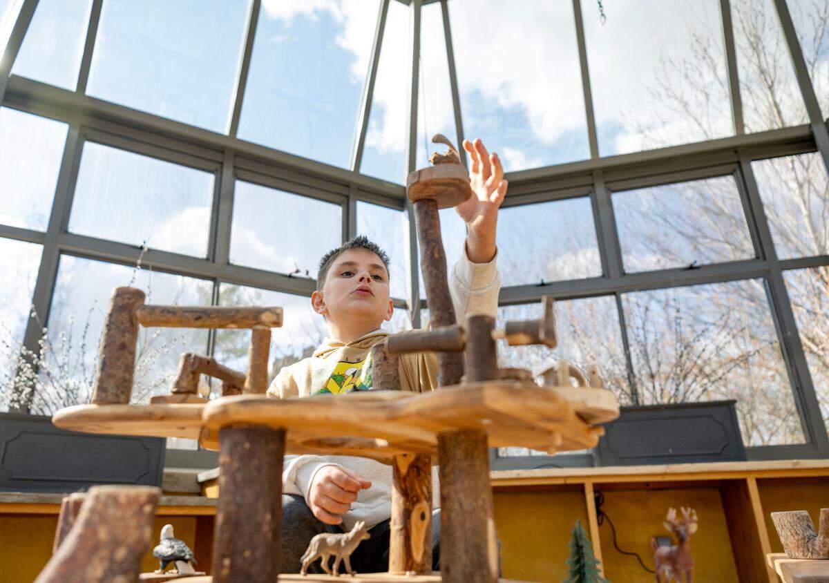 Neil Shepard, 9, places an owl figurine on the top of the treehouse tower he built in the glass house at The Arboretum at Penn State March 4, 2024.
