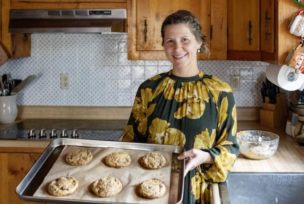 Alyssa Burns of Blackberry Cottage Bake Shoppe holds a fresh out of the oven tray of chocolate chip cookies on Friday, Nov. 14, 2025. The cookies are made with organic einkorn flour and no refined sugars.  