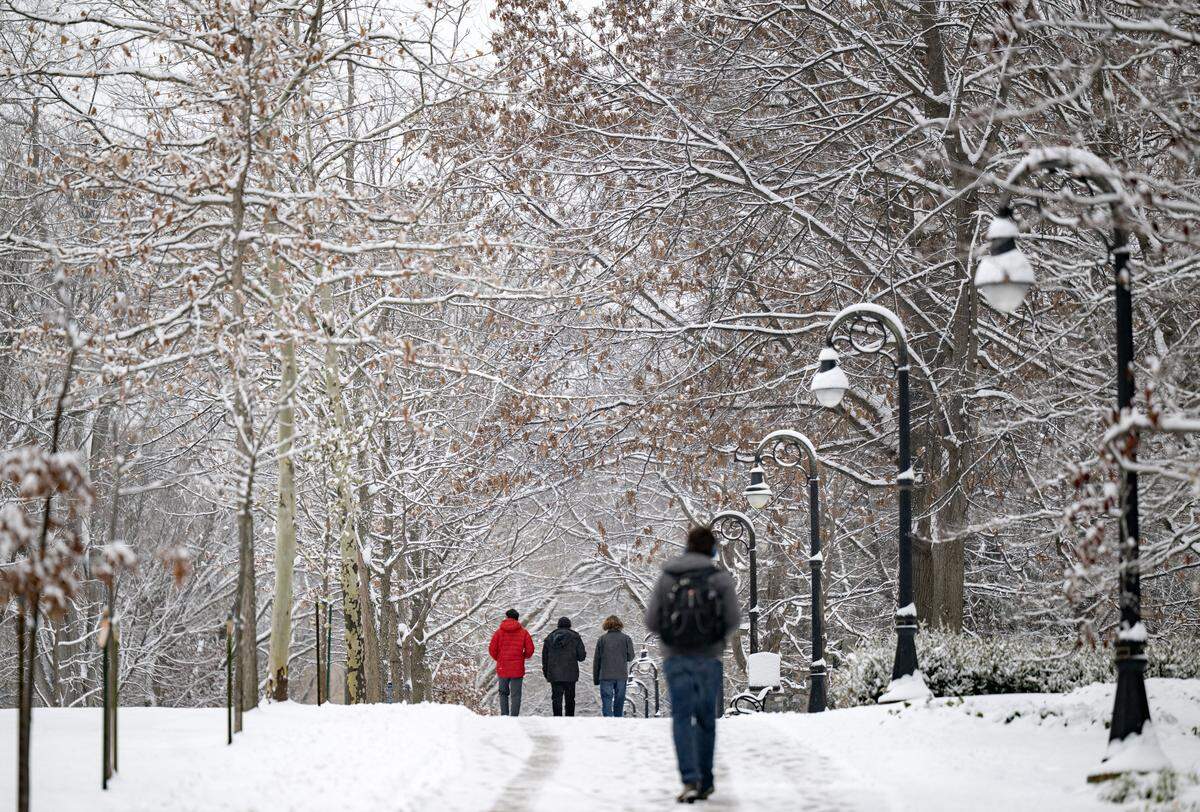 People walk along the Allen Street mall on the Penn State campus in the snow Tuesday, Dec. 2, 2025.