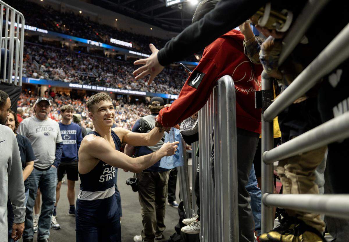 Penn State's Luke Lilledahl high-fives fans after winning the 125-pound title at the NCAA wrestling championships on Saturday, March 21, 2026.