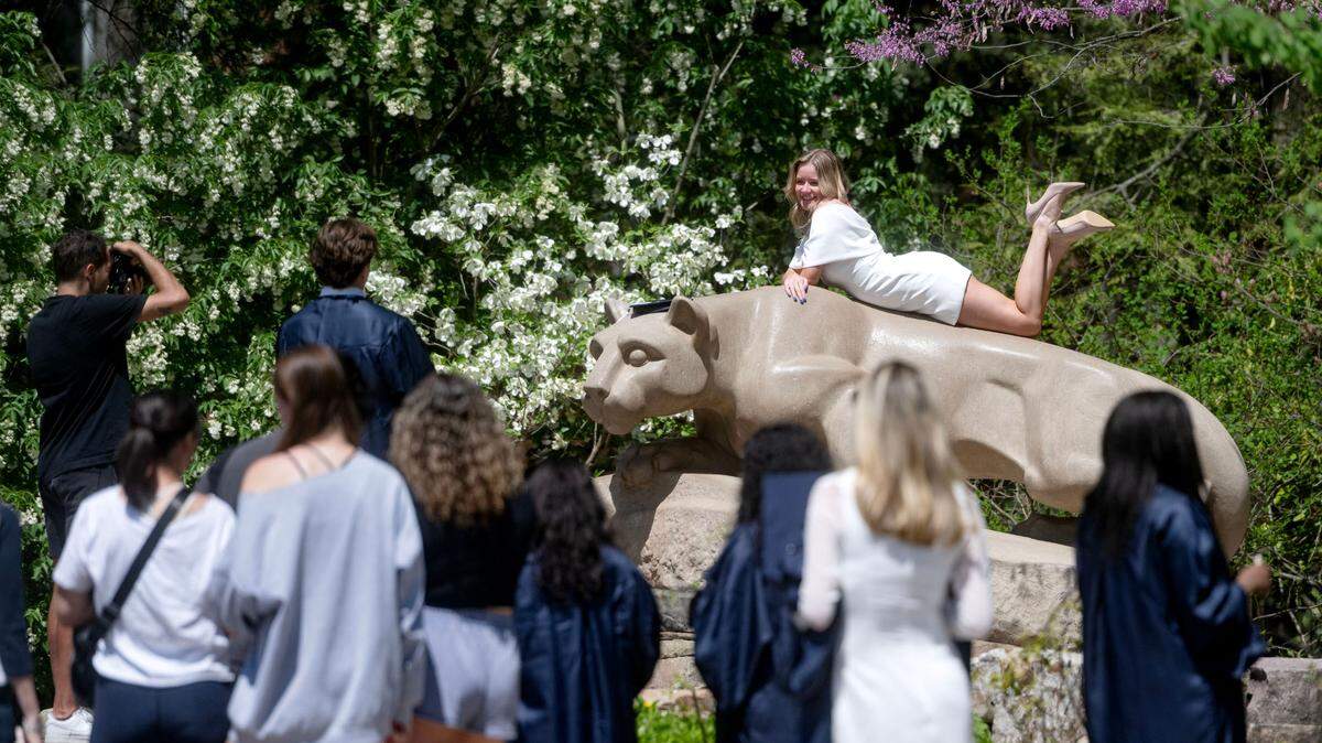 Soon-to-be Penn State graduates line up to take photos at the Nittany Lion on Wednesday, May 1, 2024.