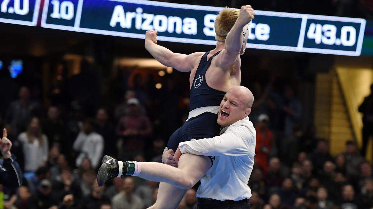 Penn State’s Bo Nickal jumps into head wrestling coach Cael Sanderson’s arms after pinning Ohio State’s Myles Martin in the 184 pounds finals during the NCAA Division I Wrestling Championships Saturday, March, 17, 2018 at the Quicken Loans Arena in Cleveland, Ohio.