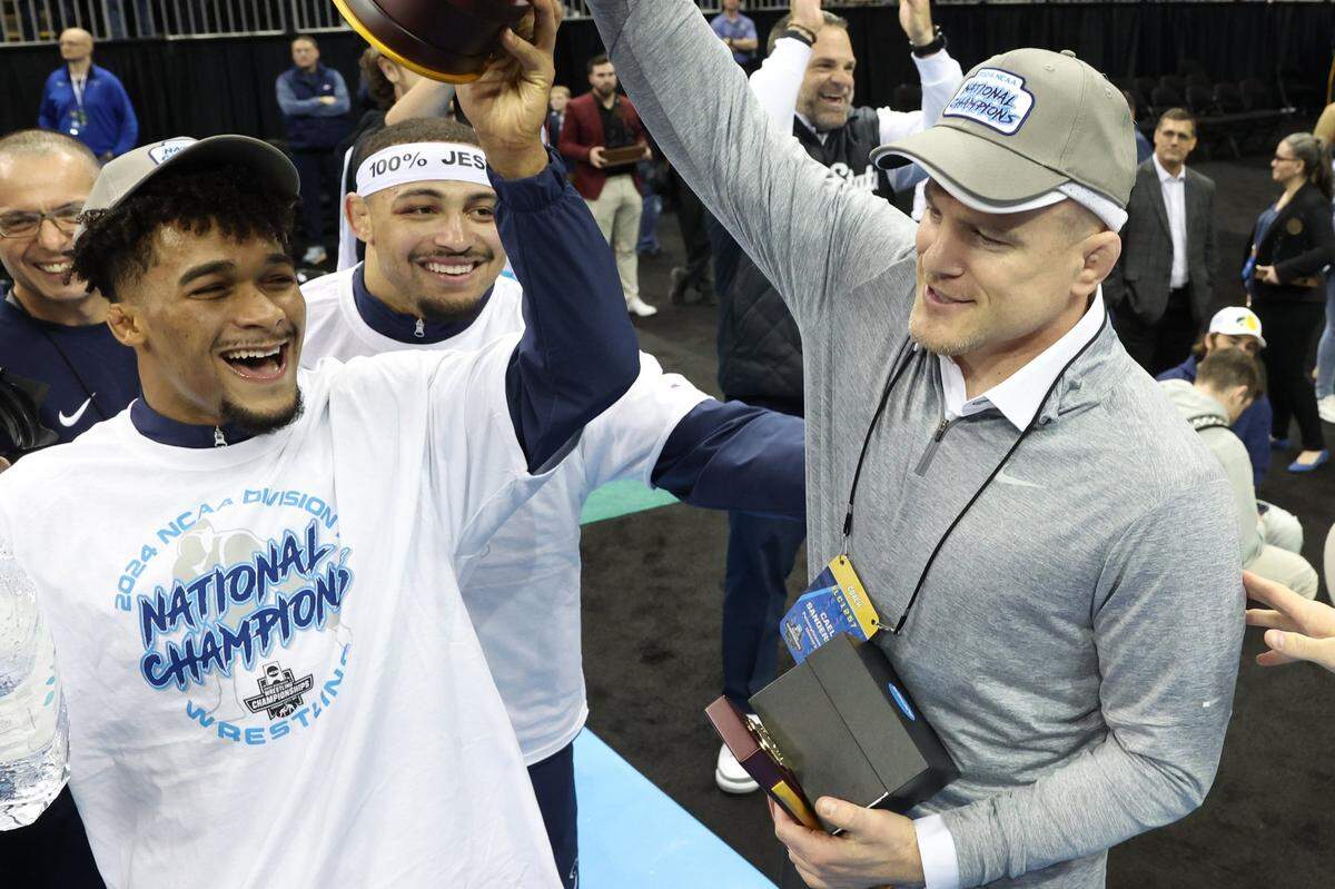 Mar 23, 2024; Kansas City, MO, USA;  174 pound Penn State Nittany Lions wrestler Carter Starocci and coach Cael Sanderson celebrate after winning the team championship at the T-Mobile Center. Mandatory Credit: Reese Strickland-USA TODAY Sports