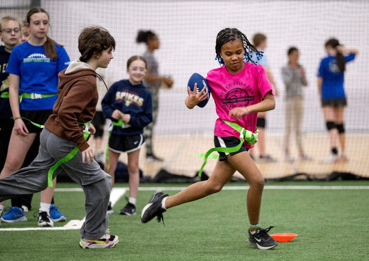 Adele Miller cuts down the field with the ball from a teammate during girls flag football practice at Nittany Valley Sports Centre on Wednesday, March 26, 2025.