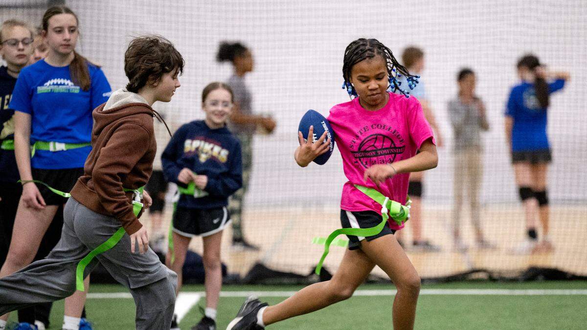 Adele Miller cuts down the field with the ball from a teammate during girls’ flag football practice at Nittany Valley Sports Centre on Wednesday, March 26, 2025.  