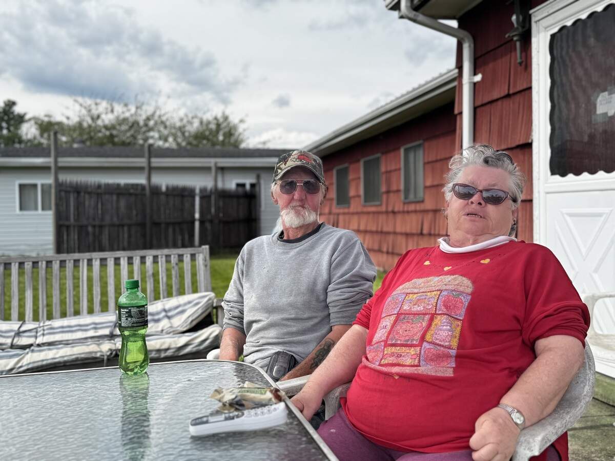 Gilbert Page and Virgie Lucas sit outside their “unit” in Pine Glen on May 27, 2026.