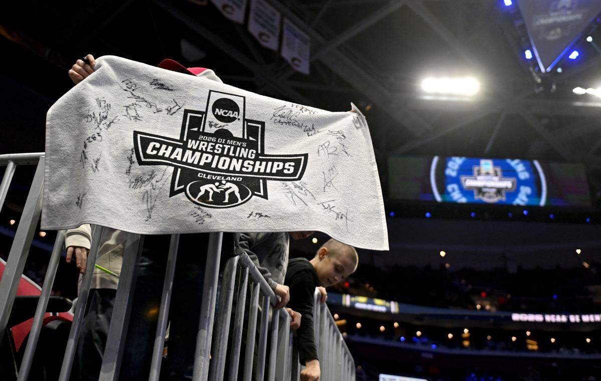 A young fan holds up a towel to get wrestling signatures before the semifinals of the NCAA wrestling championships on Friday, March 20, 2026.