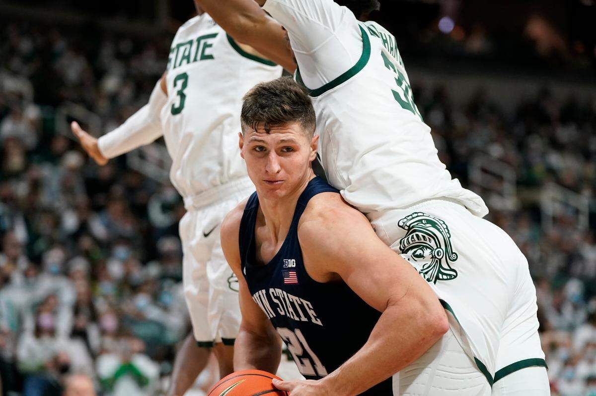Penn State forward John Harrar (21) goes around Michigan State forward Marcus Bingham Jr. (30) during the first half of an NCAA college basketball game, Saturday, Dec. 11, 2021, in East Lansing, Mich.