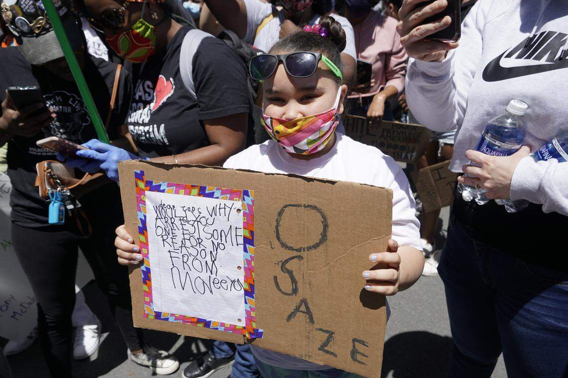 Maleeya Saunders holds a sign during Sunday’s protest in remembrance of Osaze Osagie, the 29-year-old who was killed by a State College police officer in March 2019.