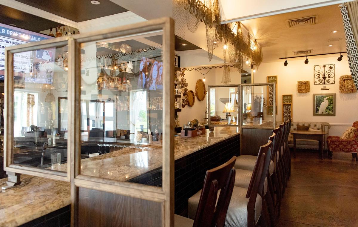 Partitions set up at the bar at Gigi’s Southern Table on Friday will help to social distance patrons.