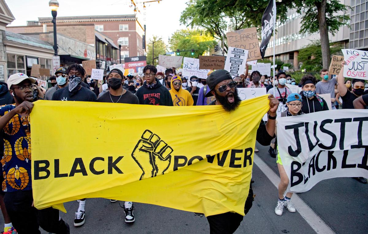 Gabriel Green leads a chant as hundreds of people march down College Avenue during a “Justice for Black Lives” protest organized by the 3/20 Coalition on Sunday.