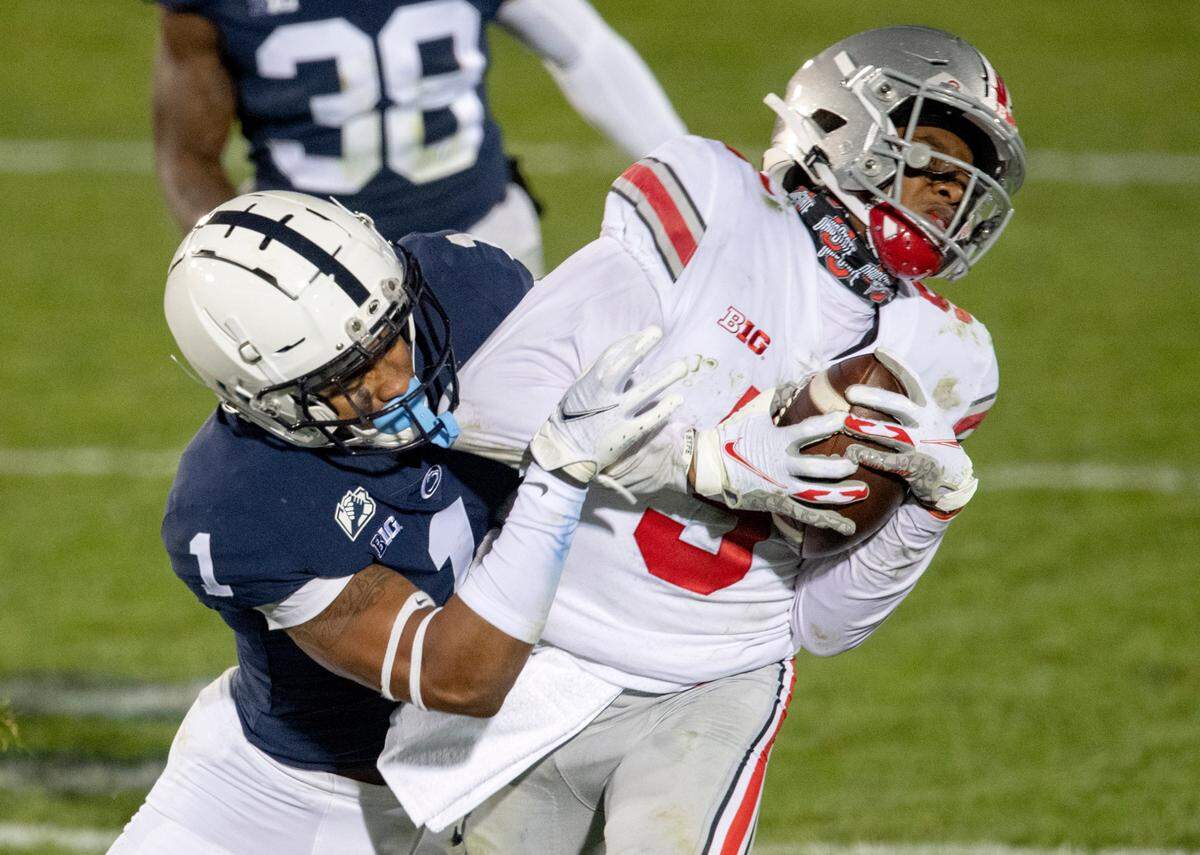 Penn State safety Jaquan Brisker pulls down Ohio State’s Garrett Wilson during the game on Saturday, Oct. 31, 2020 at Beaver Stadium.