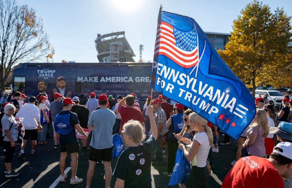 A crowd gathered to listen to speakers on the “Team Trump” bus tour during a stop in a parking lot near Beaver Stadium on Tuesday, Oct. 22, 2024.