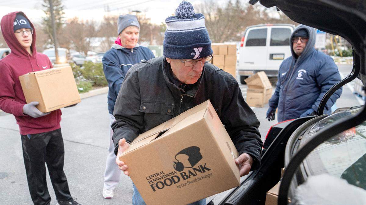 Mel Curtis and fellow volunteers help to load food into a car during the YMCA Anti Hunger program’s distribution at the Grace Lutheran Church in State College on Nov. 17, 2022.