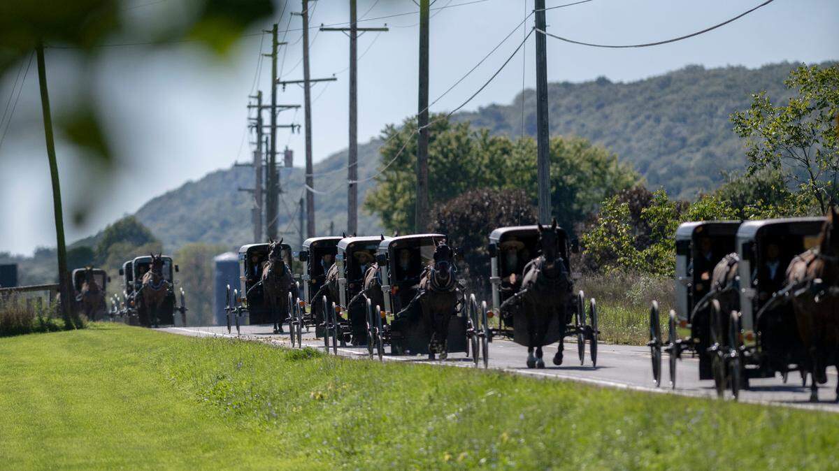 The funeral procession for Andrew, Nathan and Daniel Beiler travels along Lower Brush Valley Road on Friday.