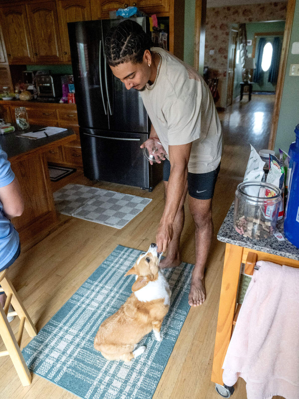 State College Spikes player Jakobi Davis gives a treat to Moose on Thursday, July 17, 2025. Moose and her owner Frank Kachurak host Spikes players through the season.