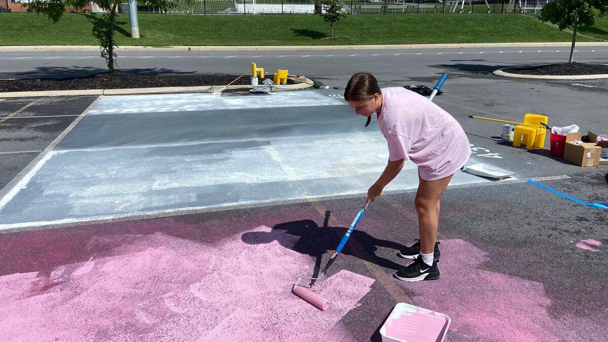 State High senior Raegan Dinant painting her parking spot in the senior lot on Wednesday, Aug. 18, 2023.