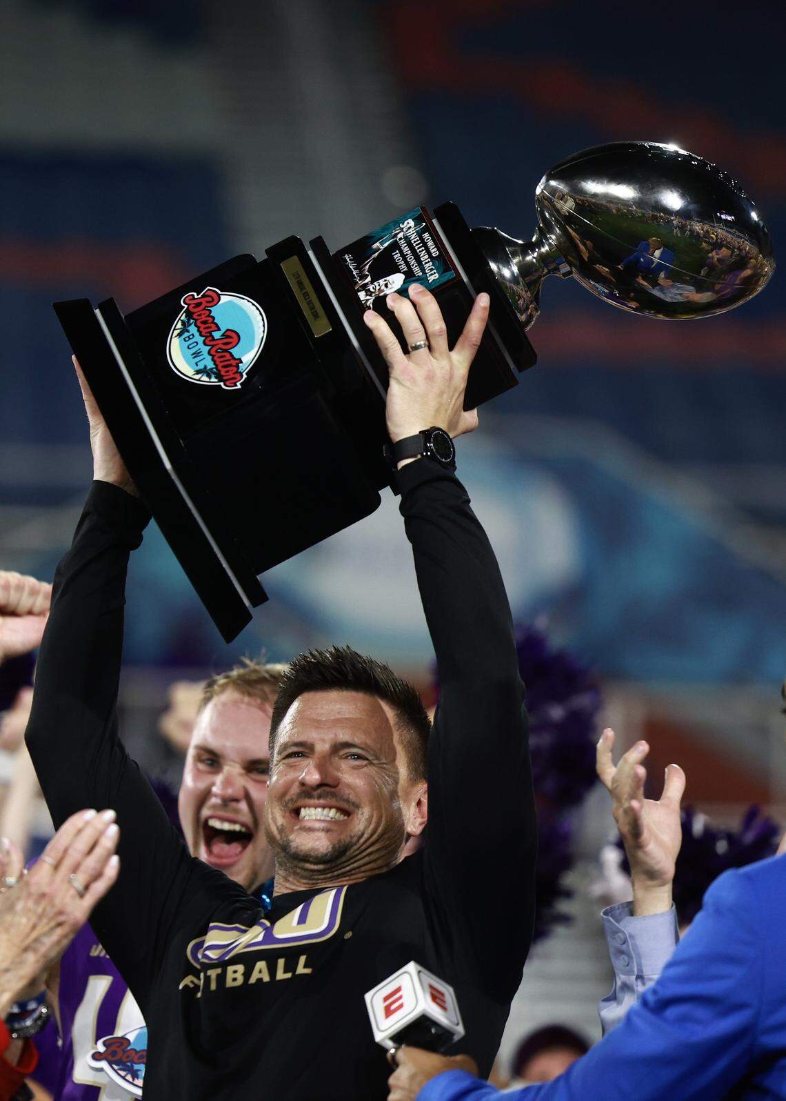 BOCA RATON, FLORIDA - DECEMBER 18: Head coach Bob Chesney of the James Madison Dukes lifts the Howard Schnellenberger championship trophy after defeating the Western Kentucky Hilltoppers at FAU Stadium on December 18, 2024 in Boca Raton, Florida.  (Photo by Carmen Mandato/Getty Images)