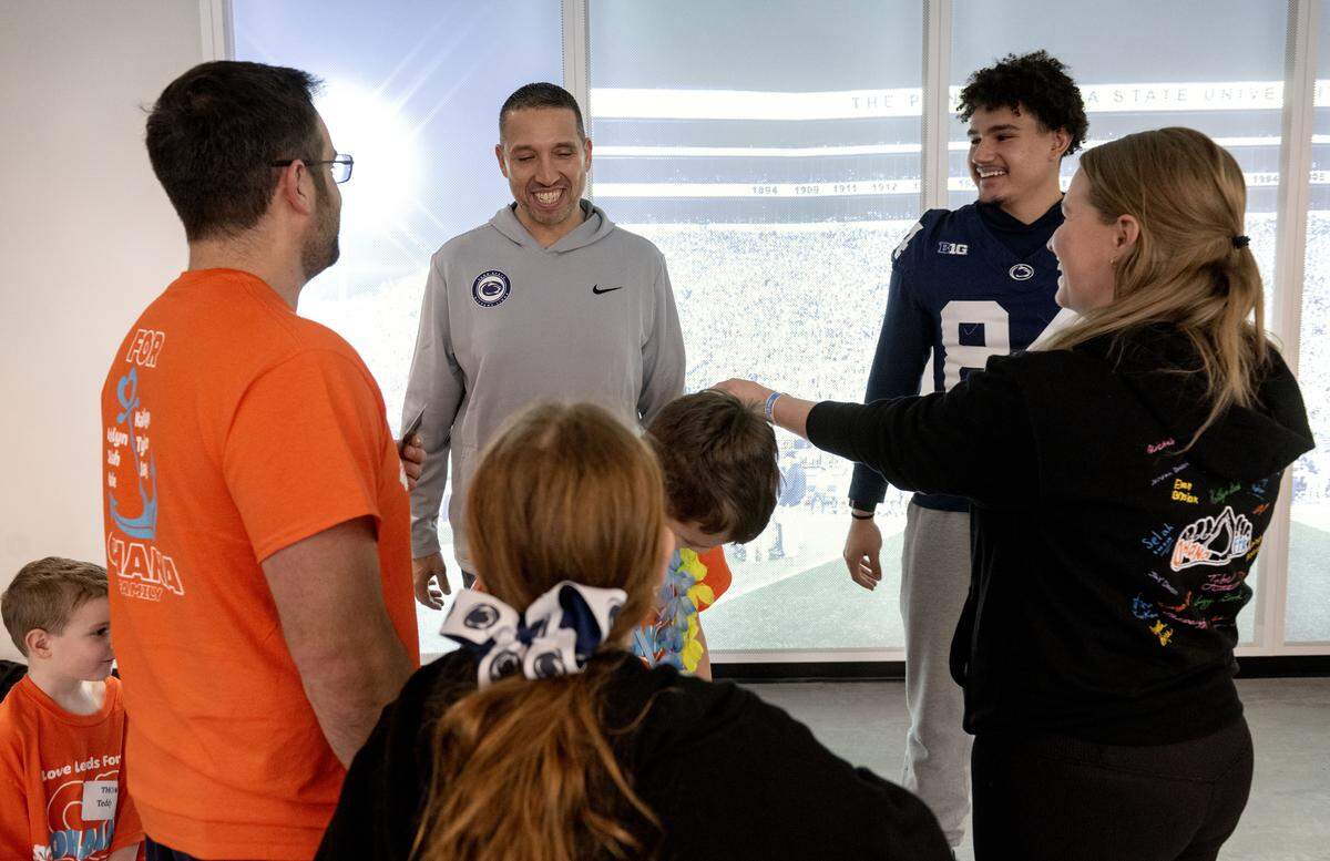 Penn State football coach Matt Campbell laughs with a Four Diamonds family as they visit the Lasch Building on Saturday, Feb. 21, 2026 as part of the Thon Explorers.  