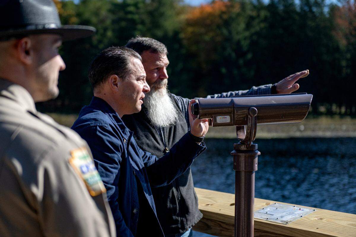 Pennsylvania Governor Josh Shapiro talks with Scott Kolesar as they try out the new color-correcting viewfinder at Black Moshannon State Park on Wednesday, Oct. 9, 2024. Shapiro and Kolesar both have a form of colorblindness and discussed how they say the colors of several trees differently through the viewfinder.
