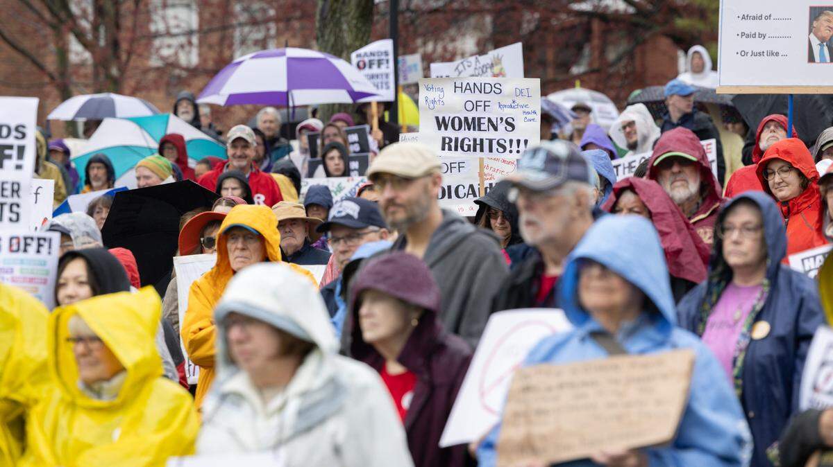 Protesters hold signs and umbrellas Saturday while listening to speakers at the “Hands Off!” rally at State College’s Sidney Friedman Park, in opposition of President Donald Trump. The event was part of a nationwide effort that saw more than 1,000 similar rallies held across all 50 states.