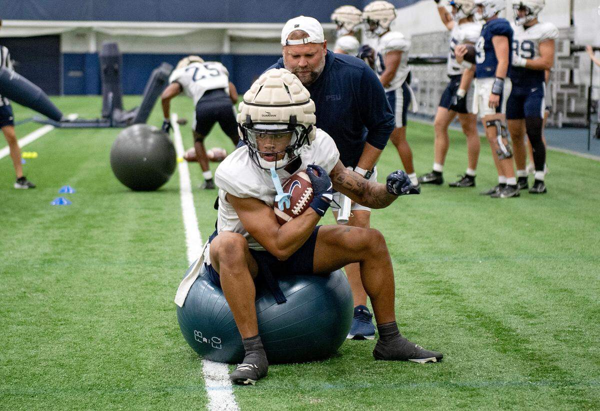 Penn State wide receiver Omari Evans runs a drill with offensive coordinator Andy Kotelnicki during practice on Saturday, Aug. 3, 2024.