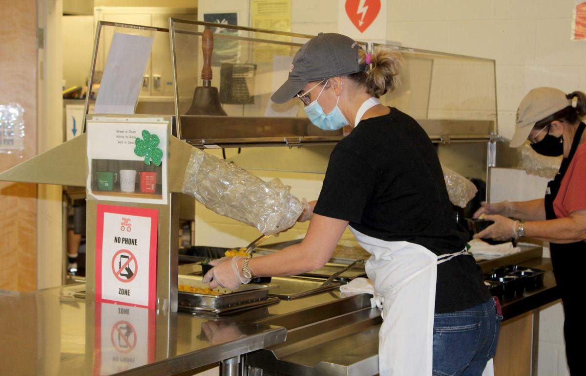 Volunteers for State College Area Meals on Wheels prepare meals on Monday at Grace Lutheran Church. The nonprofit organization is celebrating its 50th year serving community members.