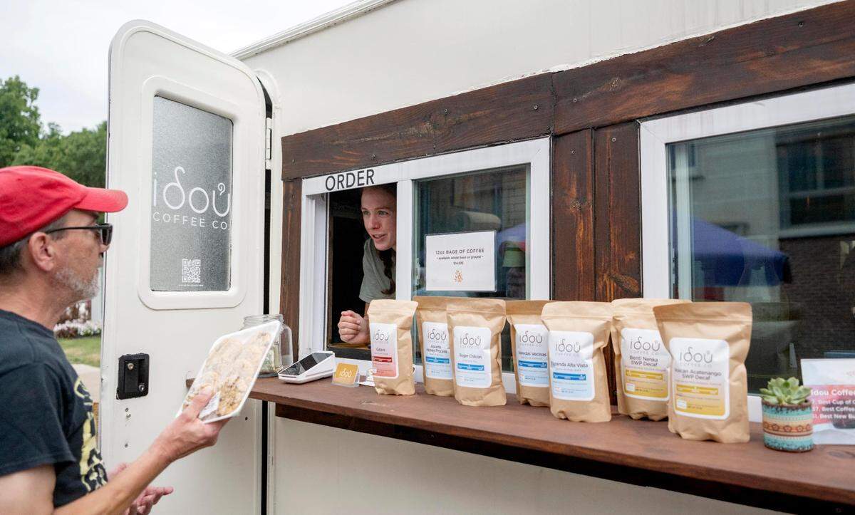 Christine Schafer chats with a customer at the Idou Coffee Co. trailer at the Downtown Farmers Market on Friday, July 29, 2022.