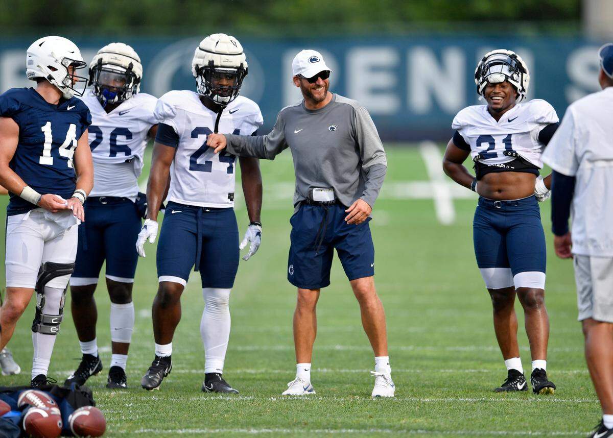 Penn State offensive coordinator Mike Yurcich jokes around with the running backs during practice on Wednesday, Aug. 11, 2021.
