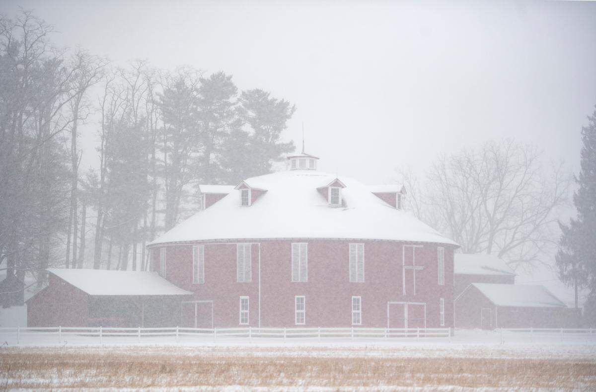 Falling snow mutes the red circle barn along Route 45 in Centre Hall on Wednesday, Feb. 20, 2019.