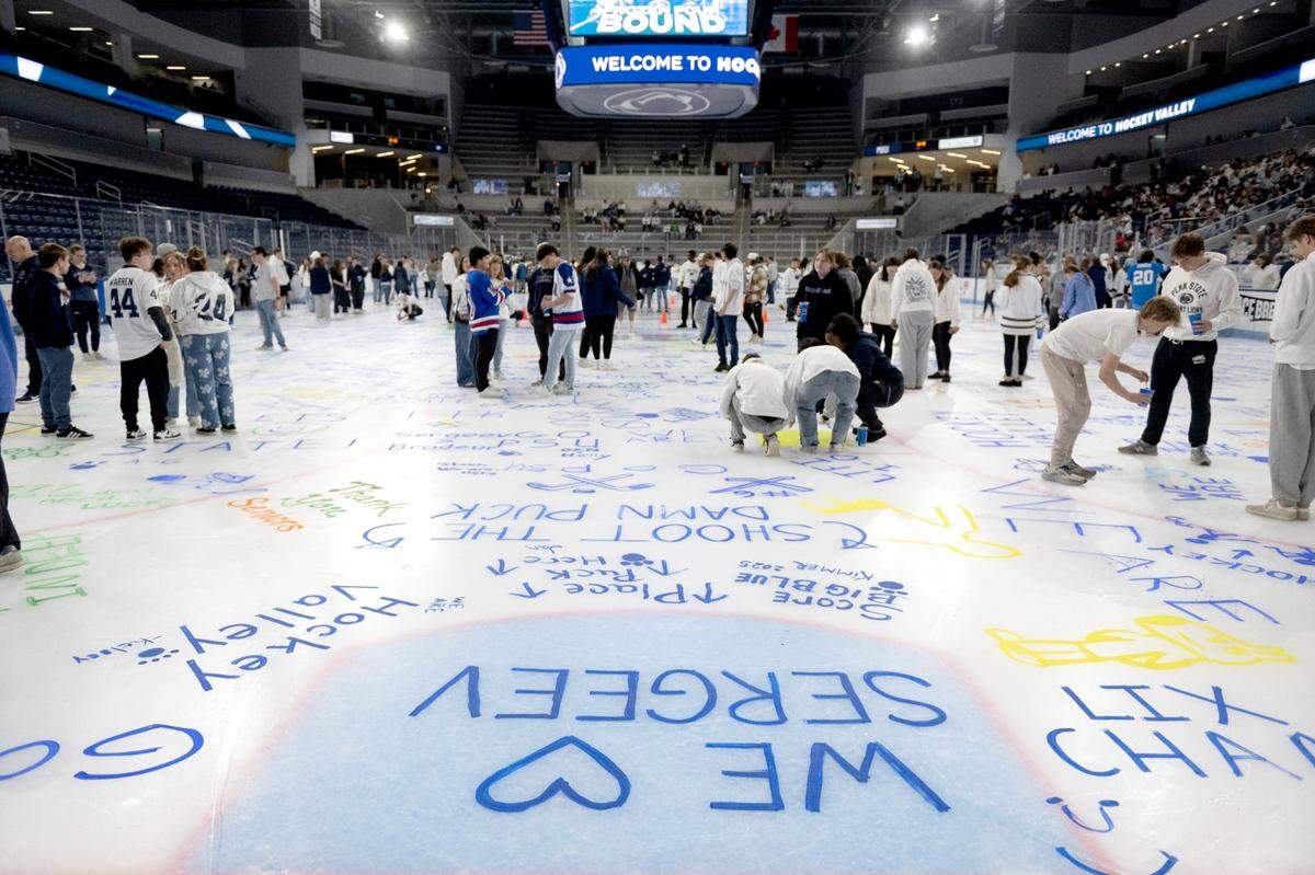 Penn State fans paint messages on the ice during the NCAA Frozen Four watch party at Pegula Ice Arena on Thursday, April 10, 2025.