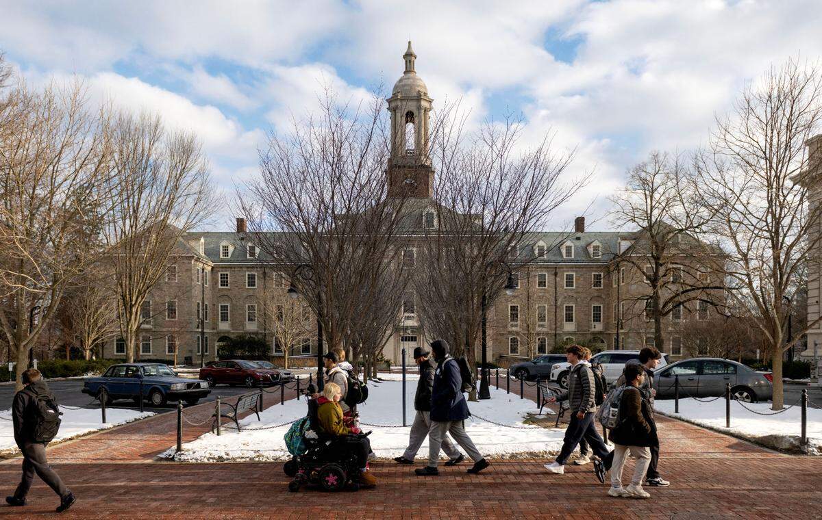 Students walk along Pollock Road and past Old Main on the Penn State campus on Friday, Jan. 17, 2025.