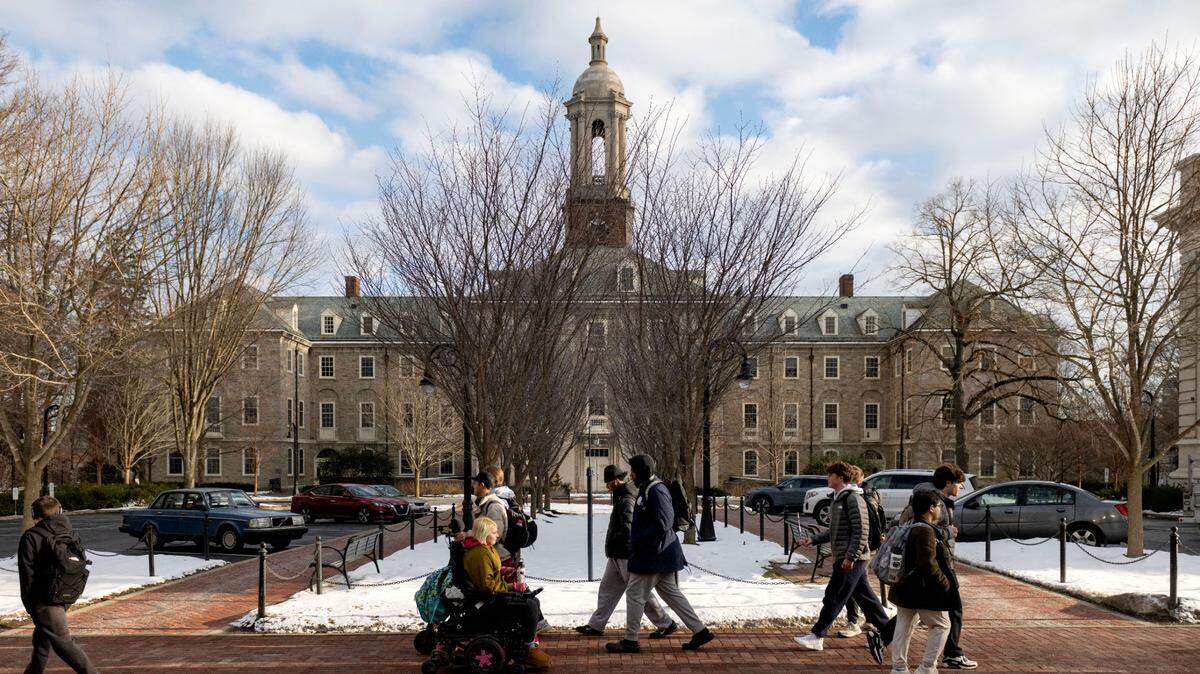Students walk along Pollock Road and past Old Main on the Penn State campus on Friday, Jan. 17, 2025.