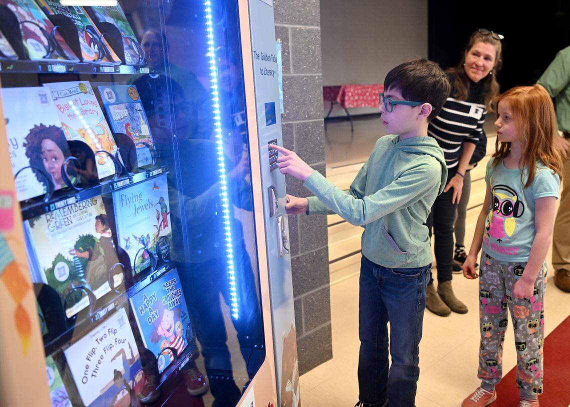 Nathan Houtz gets a book from The Golden Ticket to Literacy book vending machine after it was was introduced at Centre Hall Elementary on Friday, Feb. 3, 2023.