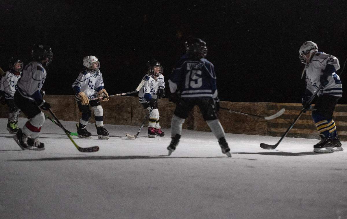 Friends enjoy the ice rink in Bill Dickson’s backyard in Lemont on Thursday, Feb. 20, 2025.