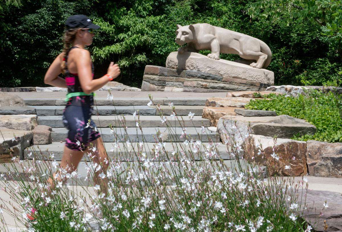 Athletes pass the Nittany Lion shrine during the 13.1 mile run for the Ironman 70.3 Pennsylvania Happy Valley on Sunday, June 30, 2024.